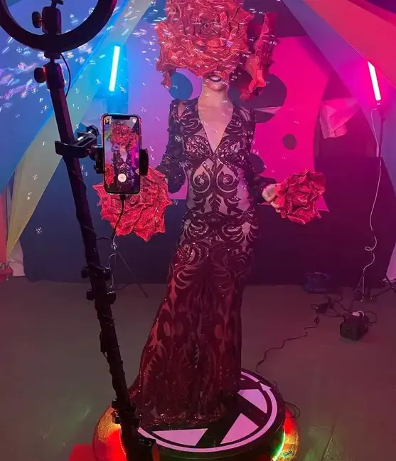Plateforme 360 rotative lors d'un événement nocturne, anneau lumineux et LED de la base allumés pendant qu'elle filme une artiste